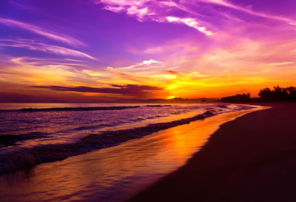 Vibrant sunset colors reflecting over a serene Brazilian beach, capturing nature's beauty.